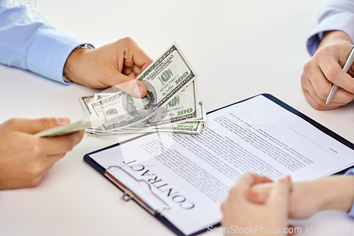 Image of close up of hands with dollar money and contract