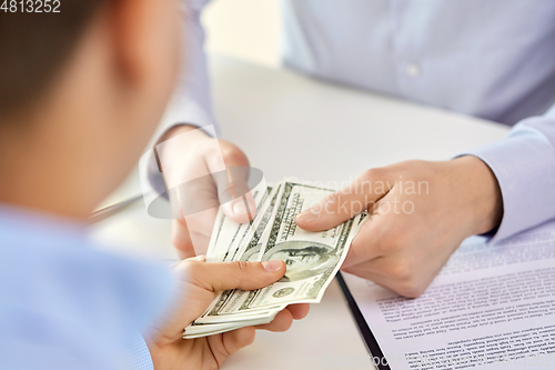 Image of close up of hands with dollar money and contract