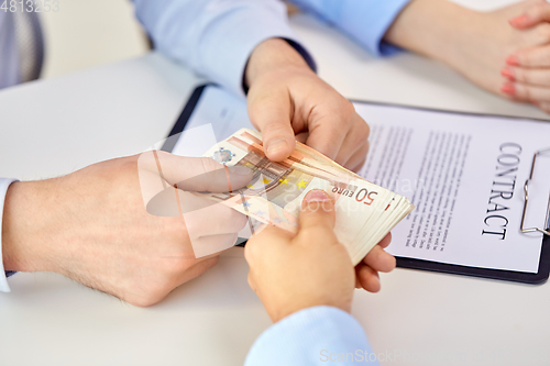 Image of close up of hands with euro money and contract