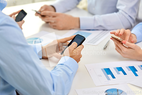 Image of businesspeople with smartphones at office