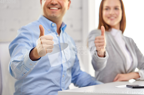 Image of happy smiling business team showing thumbs up