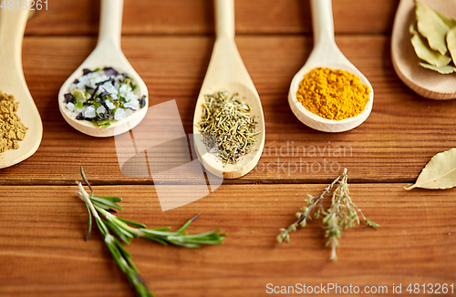 Image of spoons with spices and salt on wooden table