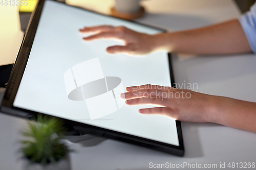 Image of hands on led light tablet at night office