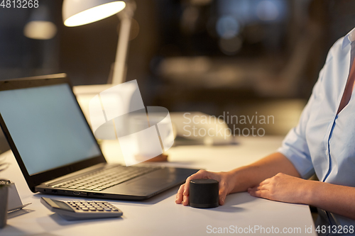 Image of close up of hand with smart speaker at office