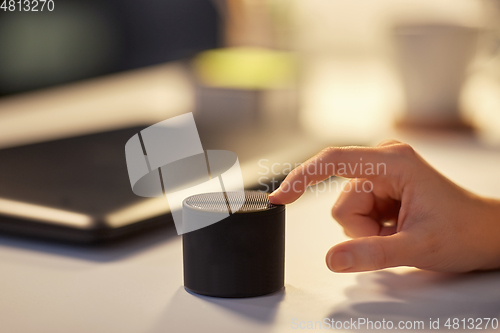 Image of close up of hand with smart speaker at office