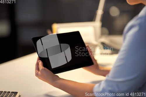 Image of businesswoman with tablet computer at night office