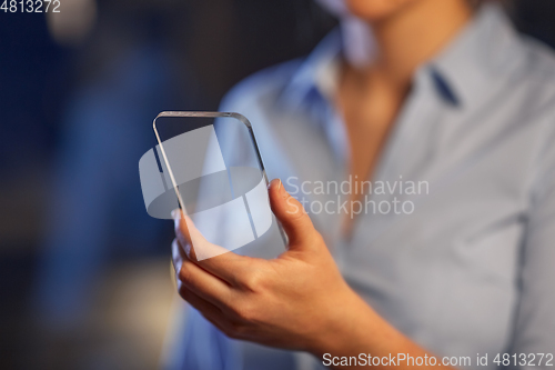 Image of close up of hand with transparent smartphone