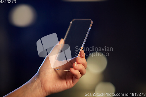 Image of close up of hand with transparent smartphone