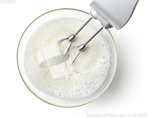 Image of beating egg whites cream with mixer in the bowl