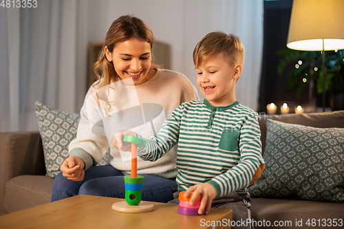 Image of mother and son playing with toy pyramid at home