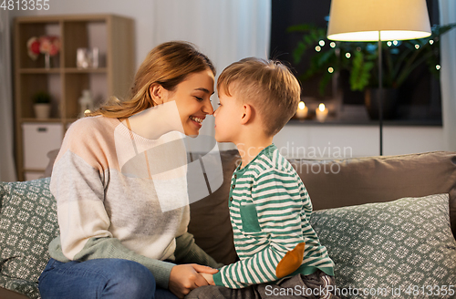 Image of happy mother and son touching noses at home