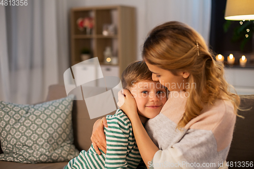 Image of happy smiling mother and son hugging at home