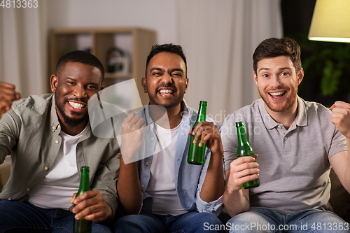 Image of happy male friends or fans drinking beer at home