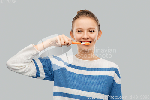 Image of happy teenage girl brushing teeth with toothbrush