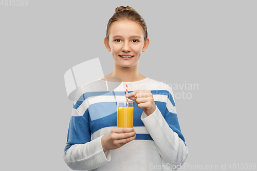 Image of smiling teenage girl holding glass of orange juice