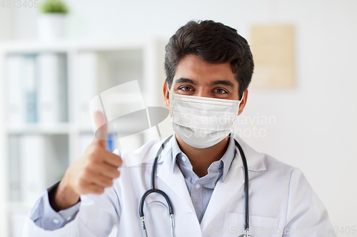 Image of doctor in medical mask at clinic showing thumbs up