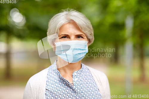 Image of senior woman in protective medical mask in park