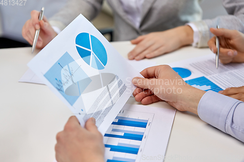 Image of business team hands with pens and charts at office