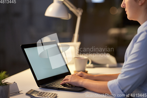 Image of businesswoman with laptop at dark night office