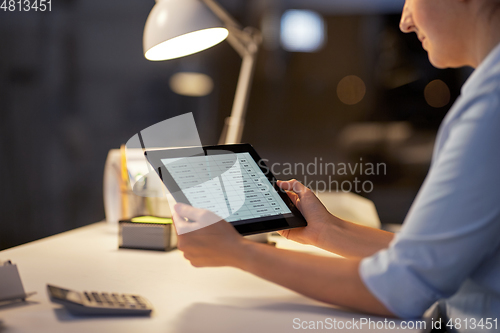 Image of businesswoman with tablet computer at night office