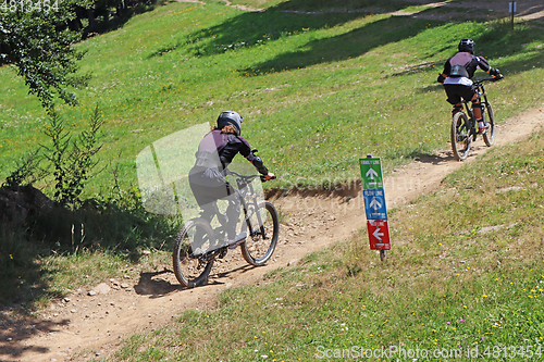 Image of Couple cycling on mountain bike, rides mountain trail.