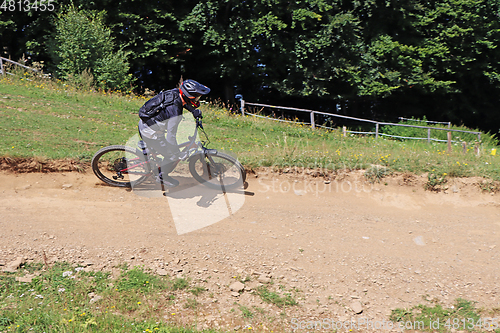 Image of Man on mountain bike rides mountain trail.