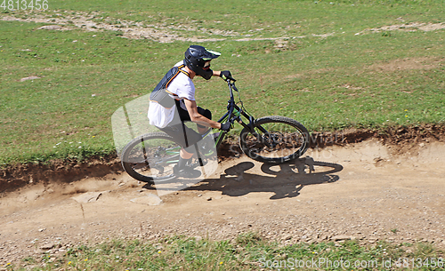 Image of Man on mountain bike rides mountain trail.