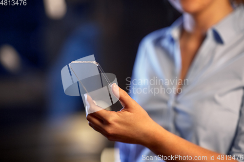 Image of close up of hand with transparent smartphone