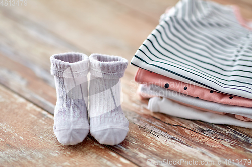 Image of close up of baby clothes on wooden table