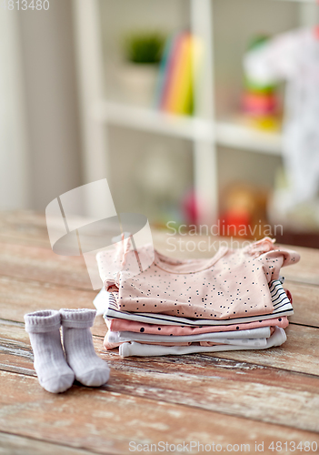 Image of baby clothes on wooden table at home