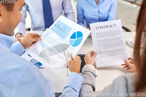 Image of close up of business team with charts and contract