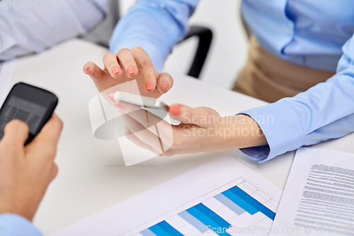 Image of businesswoman with smartphone at office