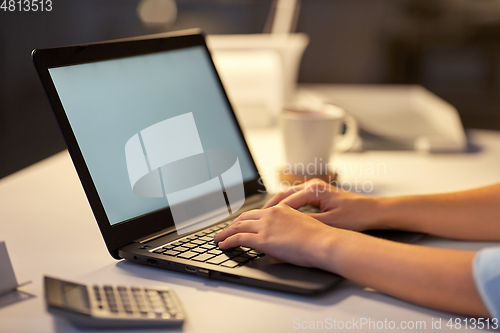 Image of businesswoman with laptop at dark night office