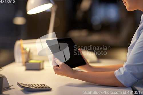 Image of businesswoman with tablet computer at night office