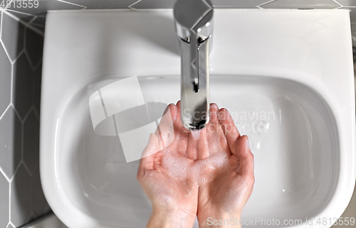 Image of close up of woman washing hands with liquid soap