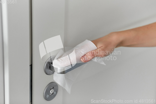 Image of hand cleaning door handle with antiseptic wet wipe