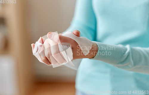 Image of woman cleaning hands with antiseptic wet wipe