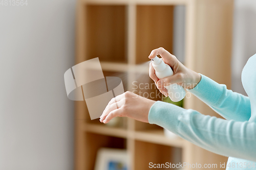 Image of close up of woman spraying hand sanitizer