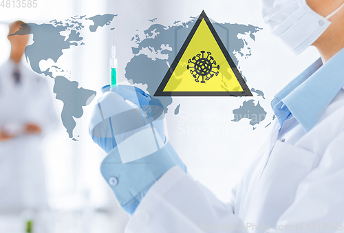 Image of doctor with syringe over coronavirus pandemic map