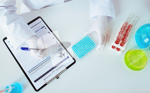 Image of scientist with tests writing report of biohazard