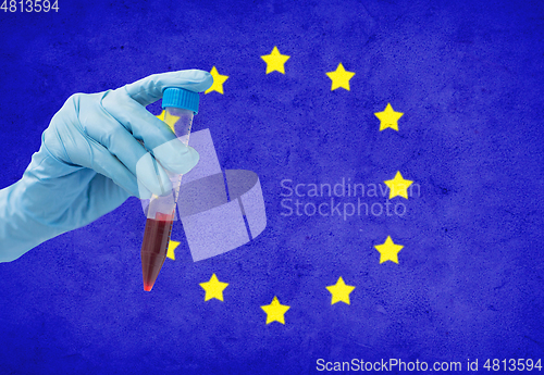 Image of hand holding test tube with coronavirus blood test