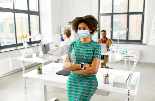 Image of woman with smart watch in medical mask at office