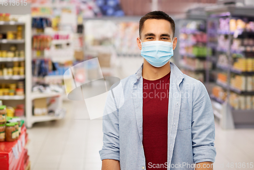 Image of young man in medical mask at supermarket