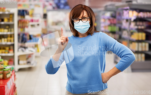 Image of angry senior woman in medical mask at supermarket