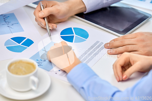 Image of business team hands with pens and charts at office