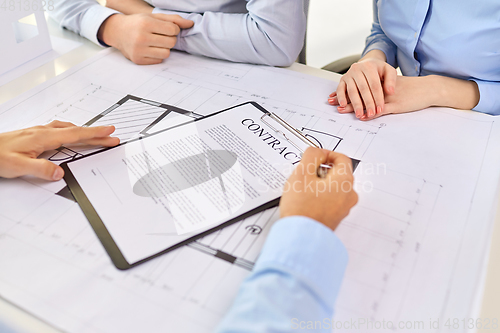 Image of realtor showing contract document to customers
