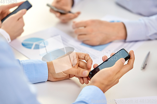 Image of businesspeople with smartphones at office