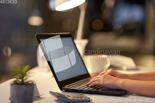 Image of businesswoman with laptop at dark night office