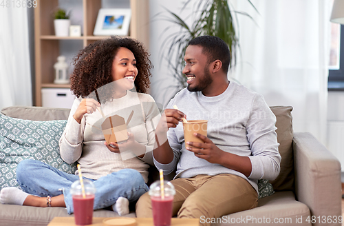 Image of happy couple with takeaway food and drinks at home