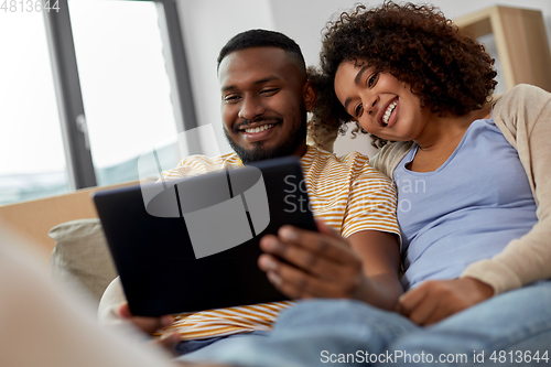 Image of happy couple with tablet pc computer at new home